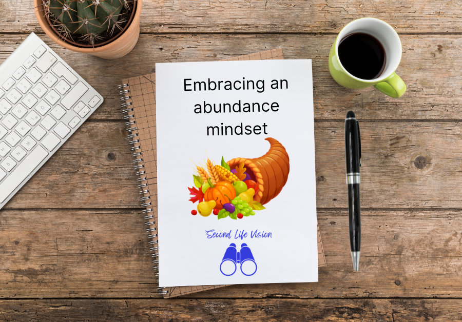 Notebook on a desktop with a pen, a cup of coffee and a laptop keyboard - Embracing an abundance mindset